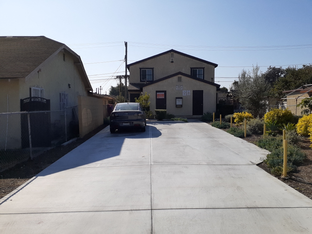 A car is parked on a driveway in front of a house.